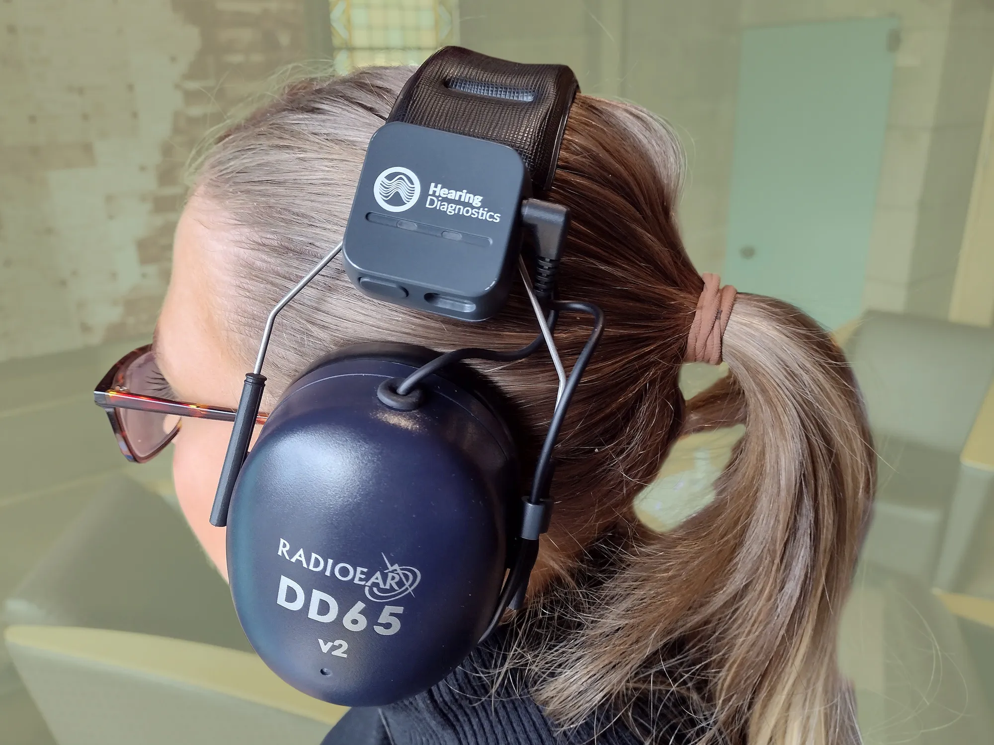 Hearing Diagnostics Device attached to headphones being worn on head